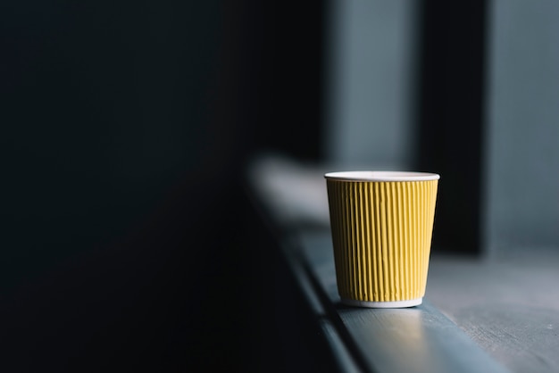 Einwegkaffeetasse am Rand der Fensterbank