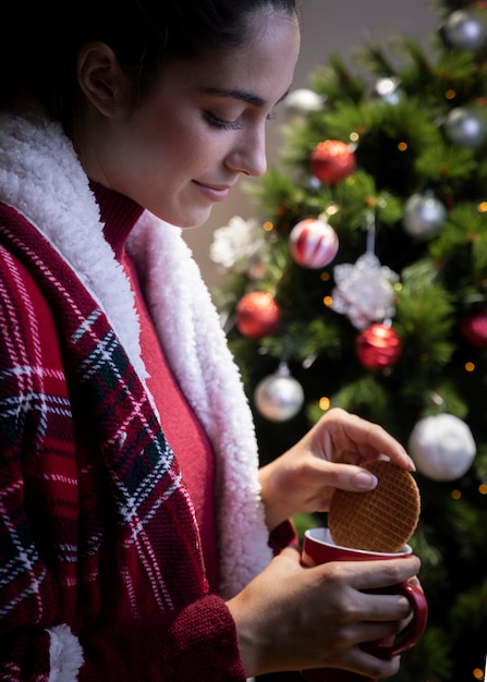 Einweichendes Plätzchen der Frau in der Teeschale