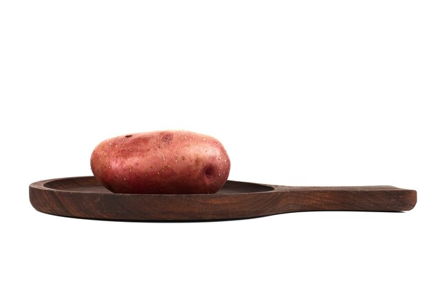 Einzelne Kartoffel auf einer Holzplatte.