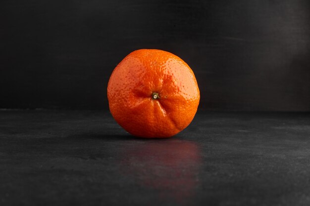 Einzelne Orange lokalisiert auf schwarzem Hintergrund.
