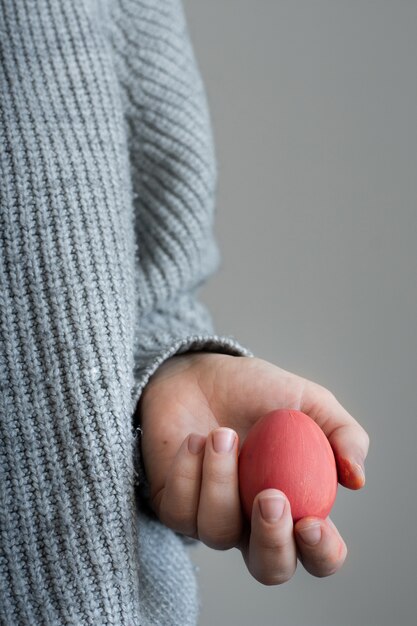 Einzelperson der Nahaufnahme, die buntes Osterei hält