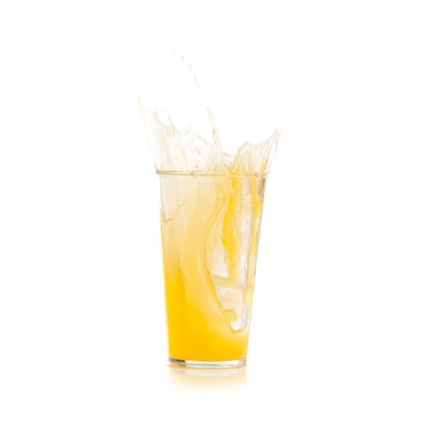 Eis fällt in ein Glas mit gelben Getränk