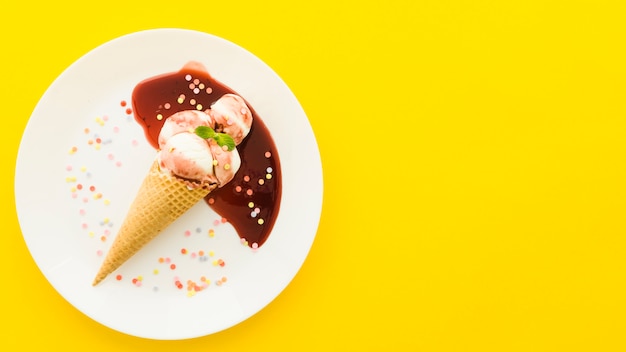 Eiscreme im Waffelkegel mit Sirup auf Platte