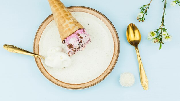 Eiscreme nahe Löffel auf Platte nahe Blumen