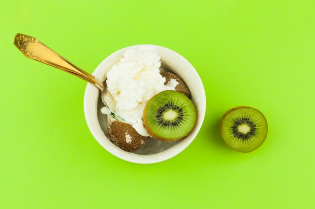 Eiscreme nahe Löffel und Kiwi in der Schüssel