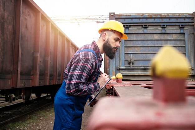 Eisenbahnarbeiter, der Raum für den Versand des Frachtcontainers prüft