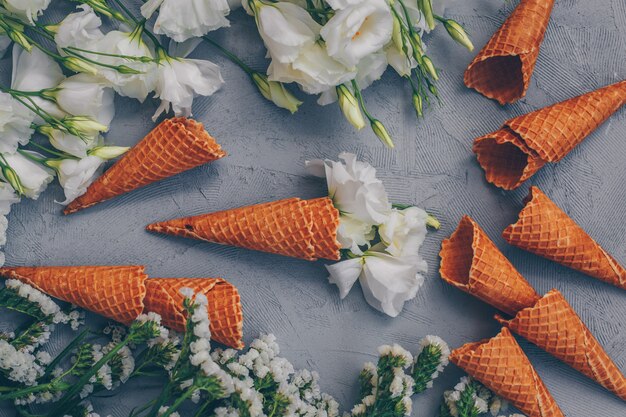 Eistüten mit Blumen Draufsicht auf Weißgrau