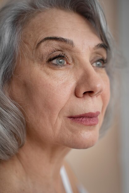 Elegante alte Frau, die weiße Kleidung trägt