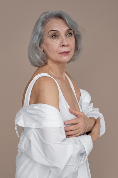 Elegante alte Frau, die weiße Kleidung trägt