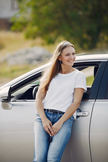 Elegante Frau, die am Auto steht