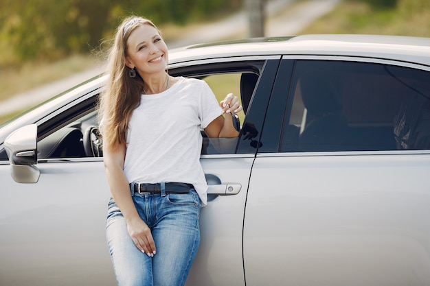 Elegante Frau, die am Auto steht