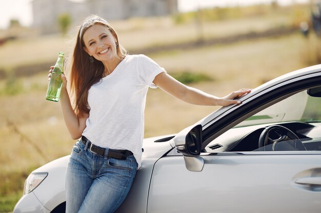 Elegante Frau, die am Auto steht