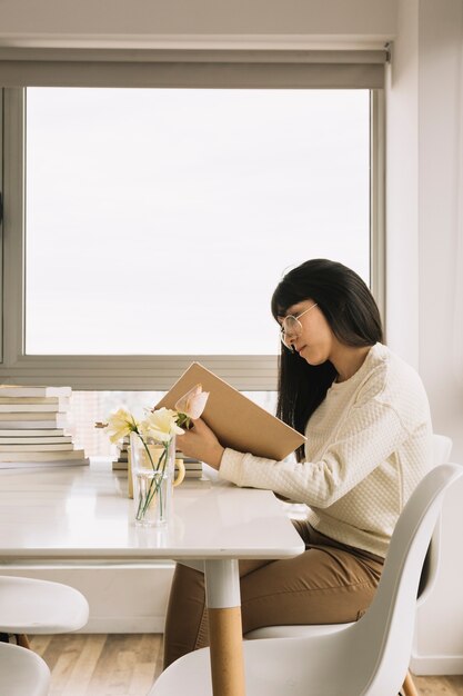 Elegante Frau, die bei Tisch liest