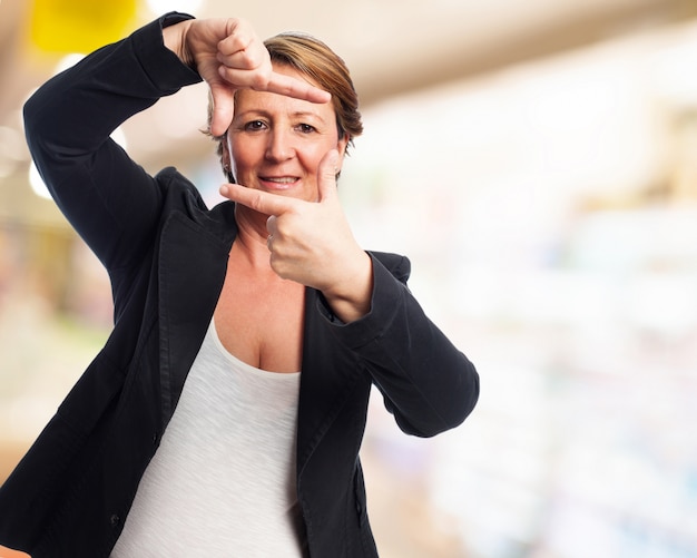 Kostenloses Foto elegante frau, die einen rahmen mit fingern