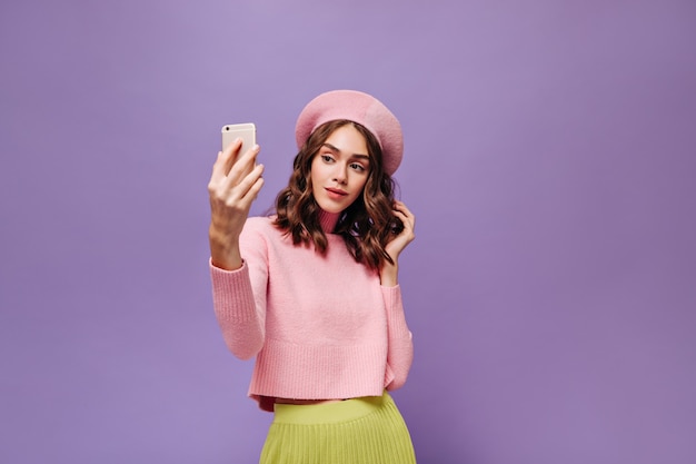 Kostenloses Foto elegante frau hält telefon und macht selfie