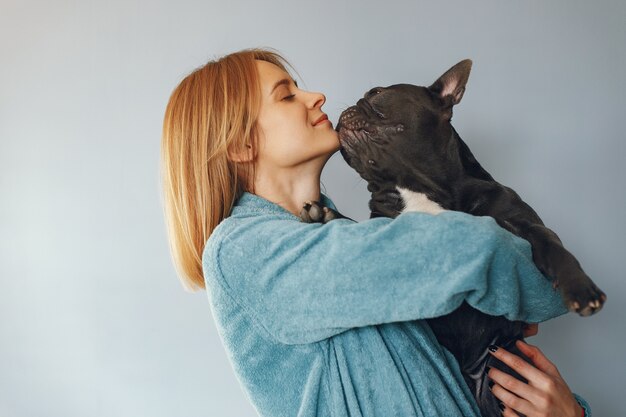 Elegante Frau im blauen Bademantel mit schwarzer Bulldogge