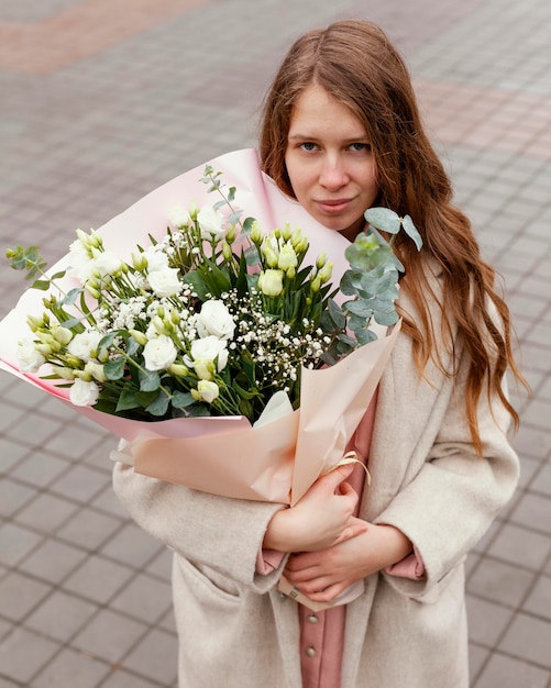Elegante Frau im Freien, die Blumenstrauß hält