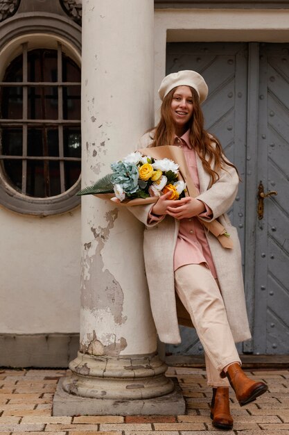 Elegante Frau im Freien, die Blumenstrauß im Frühling hält