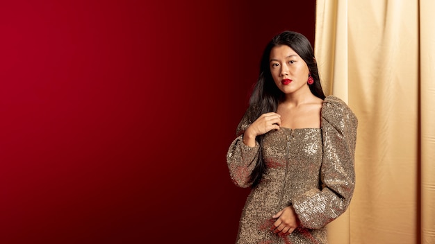 Elegante Frau im Kleid, das für chinesisches neues Jahr aufwirft