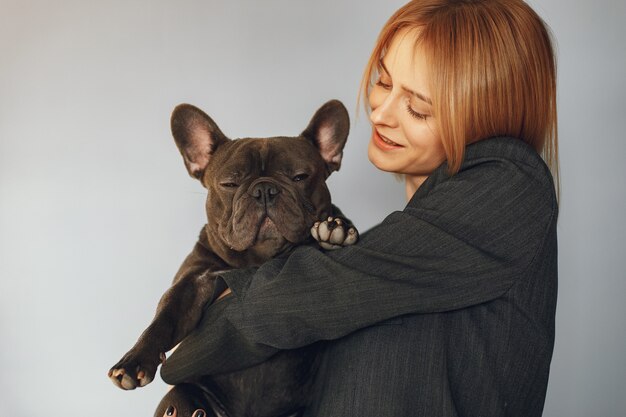 Elegante Frau in einem schwarzen Anzug mit schwarzer Bulldogge