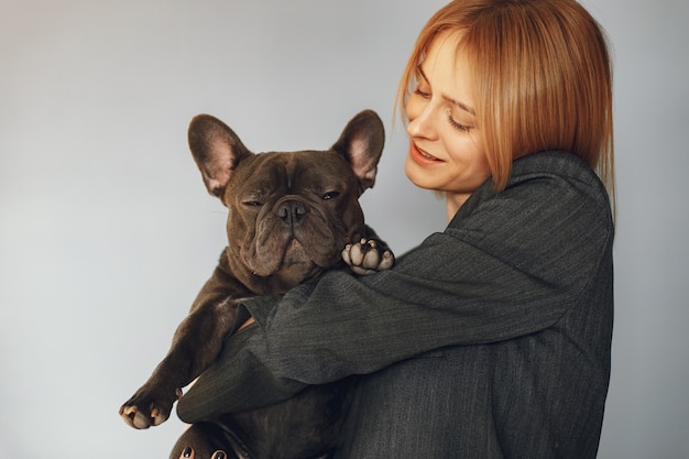 Elegante Frau in einem schwarzen Anzug mit schwarzer Bulldogge