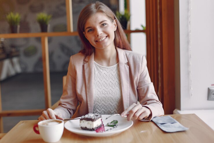 Elegante Frau in einer rosa Jacke, die Zeit in einem Café verbringt