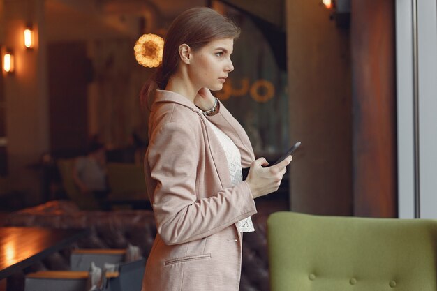 Elegante Frau in einer rosa Jacke verbringen Zeit in einem Café