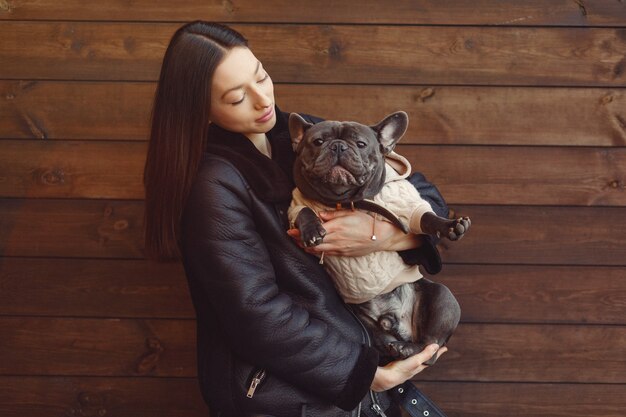 Elegante Frau in einer schwarzen Jacke mit schwarzer Bulldogge