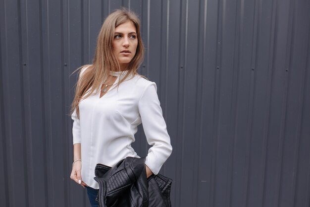 Elegante Frau mit einem weißen T-Shirt posiert