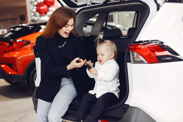 Elegante Frau mit kleiner Tochter in einem Autosalon