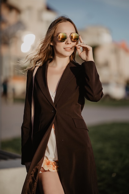 Elegante Geschäftsfrau, die Sonnenbrille am heißen Sommertag in der Stadt trägt