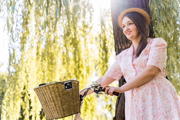 Elegante junge Frau, die mit Fahrrad aufwirft