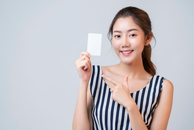 Elegante, lässige, asiatische, schöne, weibliche Lächelnhand zeigt leere Vorlagenkarte mit fröhlichem weißem Hintergrund