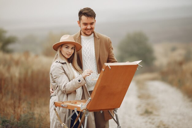 Elegante Paarmalerei in einem Herbstfeld