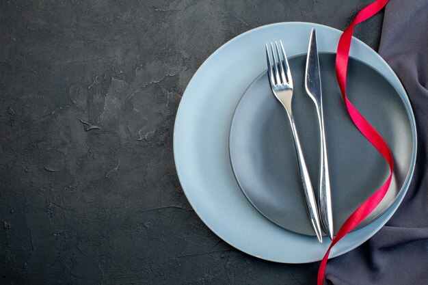 Elegante Teller mit Gabel und Messer von oben auf dunklem Hintergrund Weiblichkeit Gnade Diner Hunger bunt