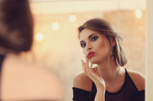 Elegante und glamouröse Frau mit Make-up posiert, Modekonzept