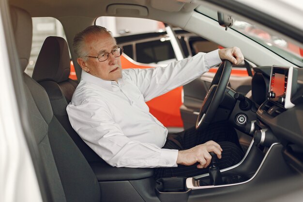 Eleganter alter Mann in einem Autosalon