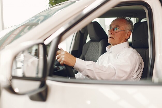 Eleganter alter Mann in einem Autosalon