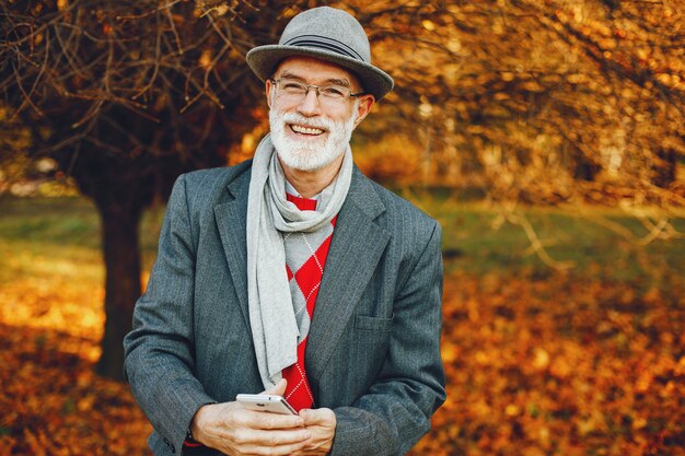 Eleganter alter Mann in einem sonnigen Herbstpark