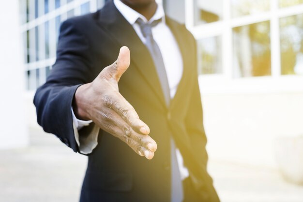 Eleganter Geschäftsmann, der heraus Hand erreicht