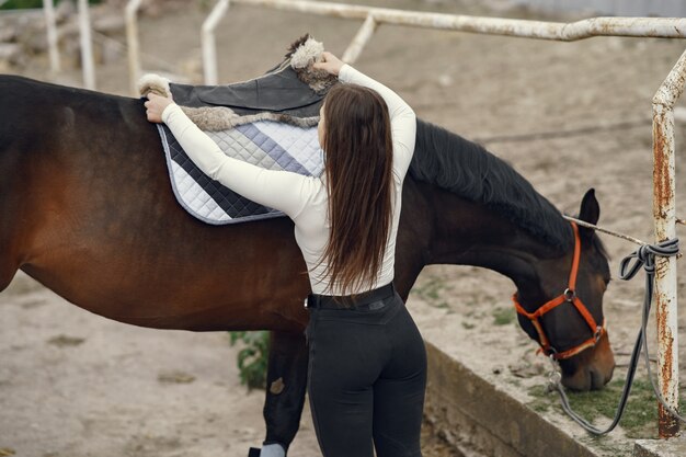 Elegantes Mädchen in einem Bauernhof mit einem Pferd