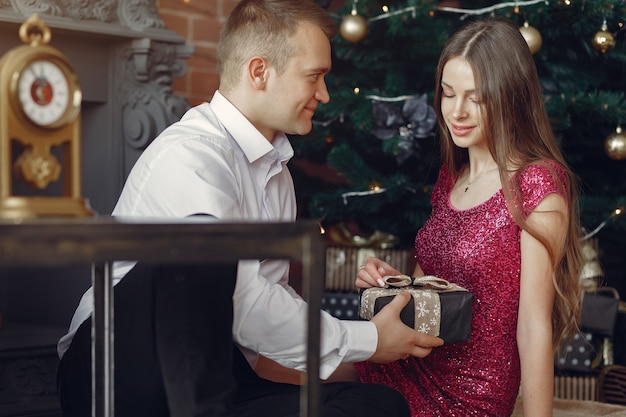 Kostenloses Foto elegantes paar zu hause in der nähe von weihnachtsbaum