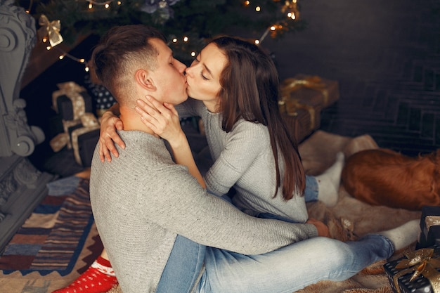 Elegantes Paar zu Hause in der Nähe von Weihnachtsbaum