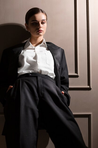 Elegantes weibliches Modell, das im Studio im Jackenanzug aufwirft. neues Weiblichkeitskonzept