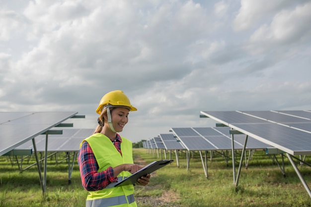 Elektrische Frau des Ingenieurs, die Solarzellen überprüft und wartet.