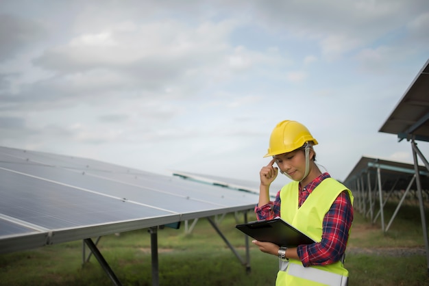 Elektrische Frau des Ingenieurs, die Solarzellen überprüft und wartet.