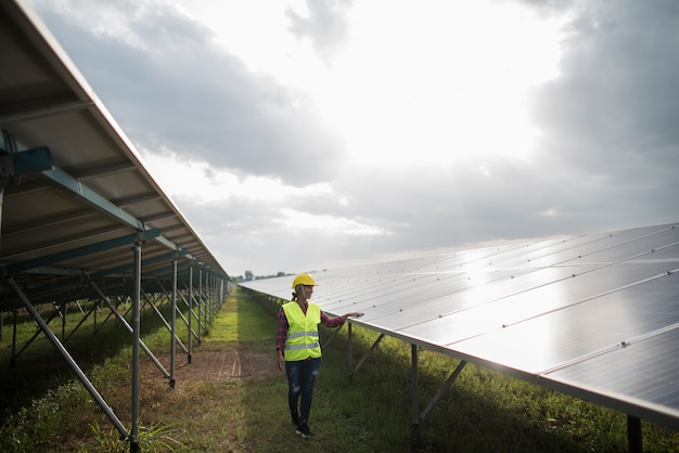 Elektrische Frau des Ingenieurs, die Solarzellen überprüft und wartet.