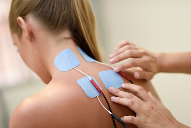 Elektrostimulation in der Physiotherapie zu einer jungen Frau