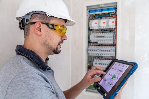 Kostenloses Foto elektrotechniker sieht konzentriert aus, während er in einer schalttafel mit sicherungen arbeitet