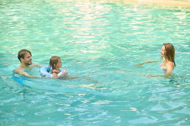 Eltern bringen ihrer Tochter das Schwimmen bei und wirken beteiligt